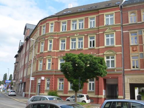 a red brick building with cars parked in front of it at Rothenberger in Chemnitz