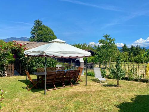 a table and chairs under an umbrella in a yard at Casa Pallanch in Fai della Paganella