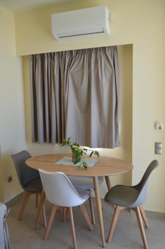 a dining room table with chairs and a window at Glyfada Beach Hotel in Glyfada