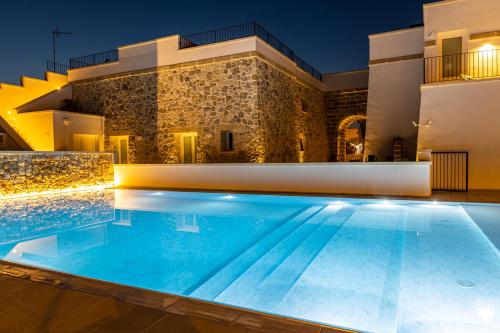 a villa with a swimming pool at night at Dimora Le Site in Torre Suda