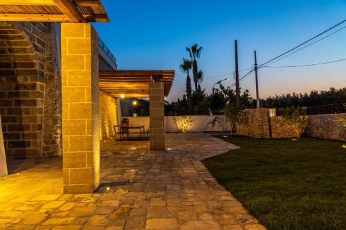 a patio of a house with a table in a yard at Dimora Le Site in Torre Suda