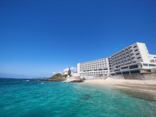 a hotel on the beach next to a body of water at Hotel Miyuki Beach in Onna