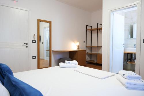 a bedroom with two white beds and a mirror at Hilltop Heaven Hotel in Sarandë
