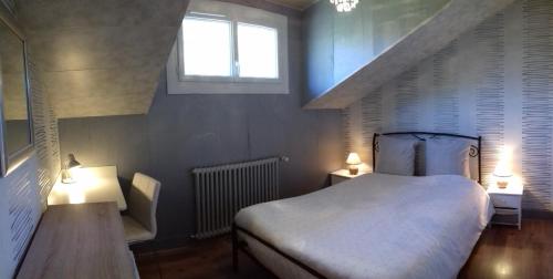 a bedroom with a bed and two tables and a window at Chambres d'Hôtes Baudelys in Pont-de-Larn