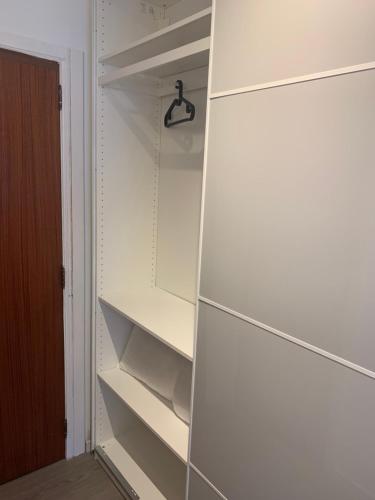 een kast met witte planken en een deur bij Les galets in Middelkerke