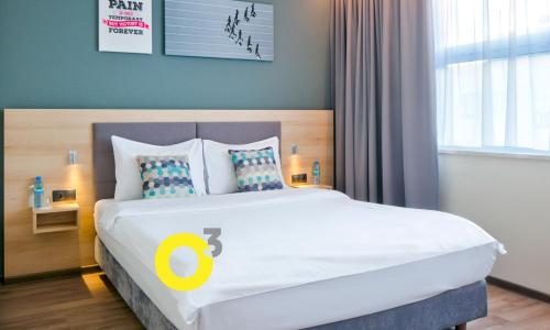 a bedroom with a large bed with a yellow circle on it at o3Hotel in Warsaw