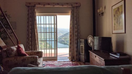 a living room with a sliding glass door with a view at Quinta da Galeira in Pinhão