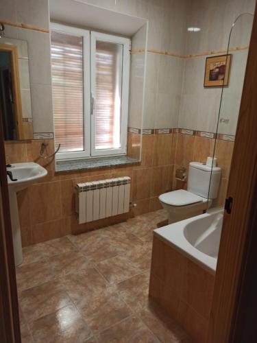 a bathroom with a tub and a toilet and a sink at La Bimborra in Becedas