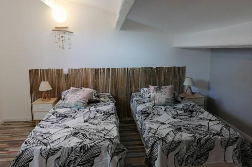 une chambre avec deux lits et deux tables de nuit dans l'établissement MAISON 5 Personnes EN GARRIGUE - PISCINE-SPA PRIVÉ, à Langlade