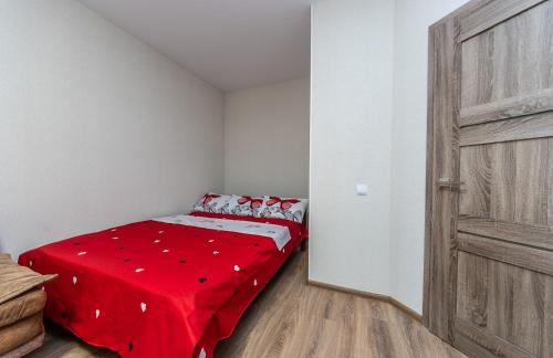 a small room with a bed with a red blanket at НОВАЯ УЮТНАЯ ОДНОКОМНАТНАЯ КВАРТИРА В новострое in Khmelʼnytsʼkyy