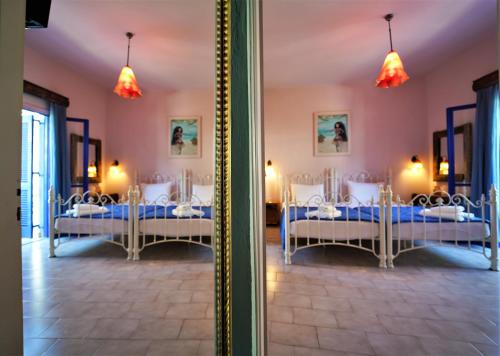 een spiegelbeeld van een kamer met vier bedden bij Antigoni Apartments in Parga