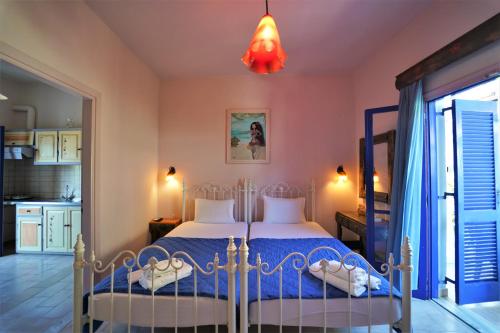 een slaapkamer met een bed met een blauw dekbed bij Antigoni Apartments in Parga