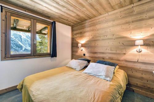 1 dormitorio con 1 cama en una pared de madera en Cosy Mountain _ free park en Montgenèvre