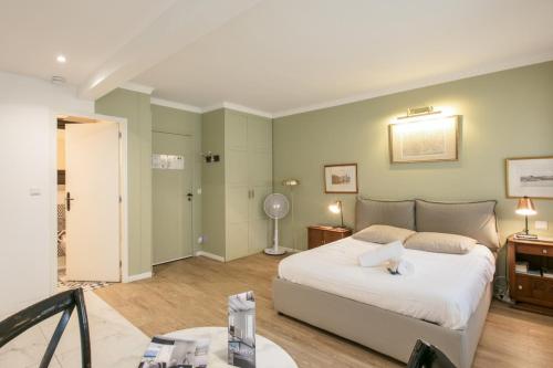 Un dormitorio con una gran cama blanca en una habitación. en Charming studio near Tour Eiffel Invalides Beaugrenelle, en París