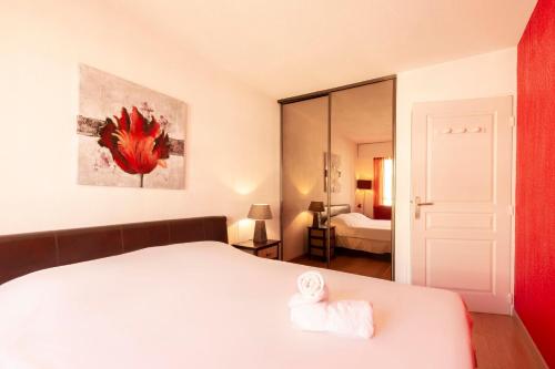 una camera con letto bianco e specchio di Quartier Vauban 2 bedroom apartment a Antibes