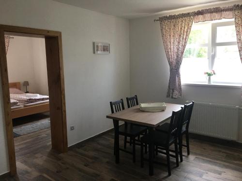 a dining room with a table and chairs and a window at Apartmány Přeseka in Třeboň