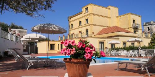 a vase of pink flowers in front of a building at Hotel Villa Igea in Sorrento