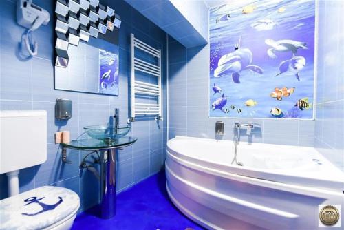 niebieska łazienka z wanną i umywalką w obiekcie Casa Marinarului w mieście Oradea