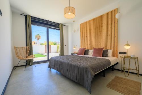 a bedroom with a large bed and a large window at VILLA MI LUNA in Torrevieja