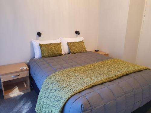 a small bedroom with a bed with a night stand at Havelock Garden Motel in Havelock