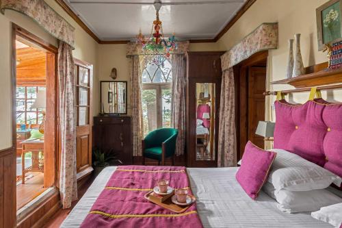 ein Schlafzimmer mit einem großen Bett mit lila Kissen in der Unterkunft StayVista at Sidhowal Lodge 1BR w Comp Breakfast in Shimla