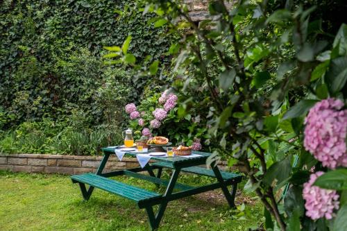 a picnic table with food on it in a garden at StayVista at Sidhowal Lodge 1BR w Comp Breakfast in Shimla