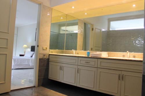 a bathroom with a sink and a large mirror at Kemang Utara Creative Villas in Jakarta