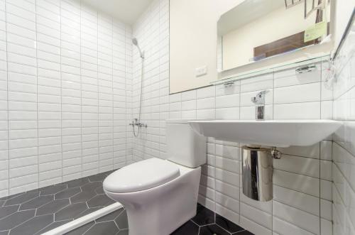 a white bathroom with a toilet and a sink at The Lin Inn in Kenting