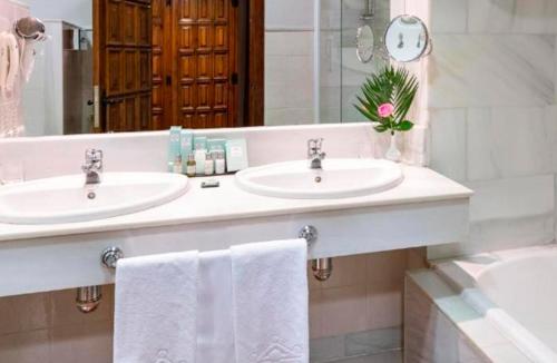 a bathroom with two sinks and a large mirror at Parador de Pontevedra in Pontevedra