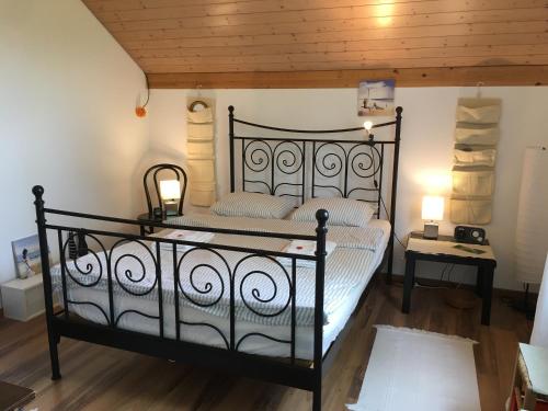 uma cama preta num quarto com tecto em madeira em Villa Modern em Ufhusen