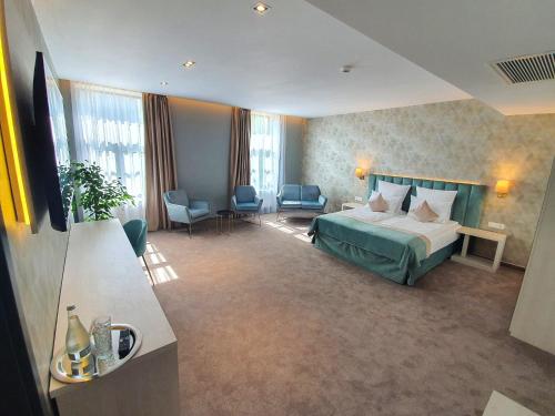 a hotel room with a bed and some chairs at JOYME Hotel in Sibiu