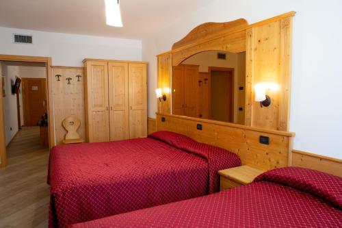 ラヴィースにあるHotel Ristorante Alla Naveのベッドルーム1室(ベッド2台、鏡付)