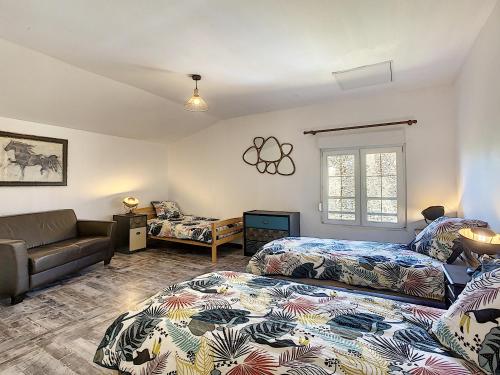 a bedroom with two beds and a couch at Gîte les Gambettes in Amel-sur- lʼÉtang