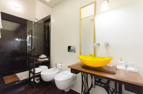 a bathroom with a yellow sink and a toilet at Dimora Novecento in Pescara