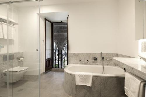 a bathroom with a tub and a toilet and a sink at Parador de Santiago - Hostal Reis Catolicos in Santiago de Compostela