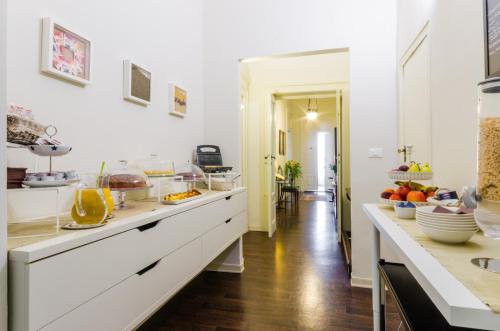 a kitchen with white cabinets and fruits on the counter at Dimora Novecento in Pescara