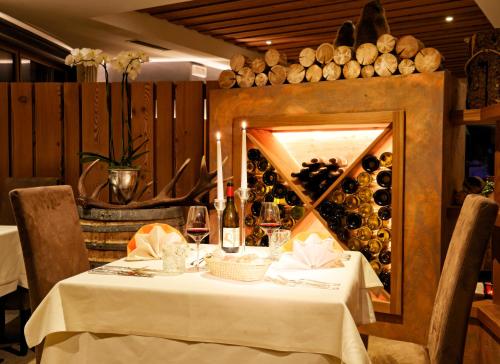 a table in a restaurant with a wall of wine bottles at Montresor Hotel Pfeldererhof in Pfelders