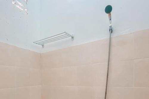 La salle de bains est pourvue d'un pommeau de douche et d'un plafond. dans l'établissement RedDoorz Syariah near RS Harapan Bunda Banda Aceh, à Geutieue