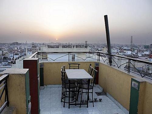 een tafel en stoelen op een balkon met uitzicht op de stad bij Ganga Fuji Home in Varanasi