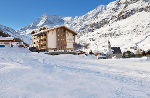a building in the middle of a snow covered mountain at Montresor Hotel Pfeldererhof in Pfelders