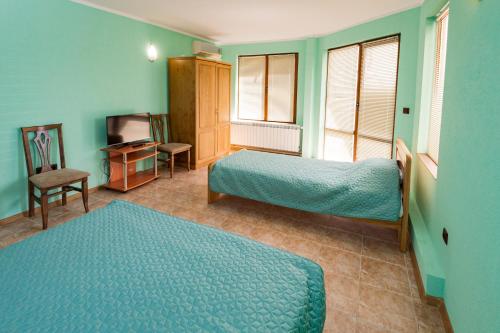 a hotel room with two beds and a television at Апартамент Морски бриз in Balchik