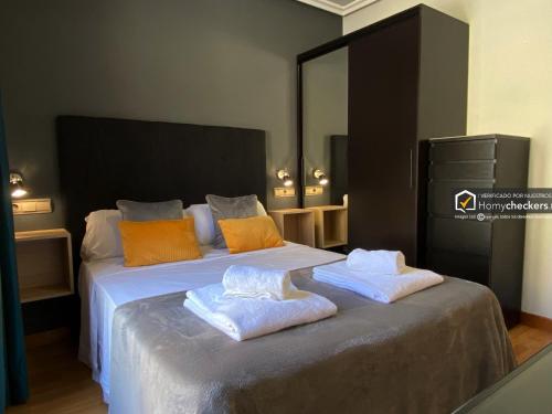 Un dormitorio con una cama grande con toallas. en Alojamiento Centro de Salamanca, en Salamanca