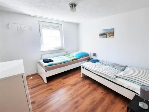 two beds in a room with wooden floors at Work& Stay Apartment mit 2 Schlafzimmern in Reutlingen