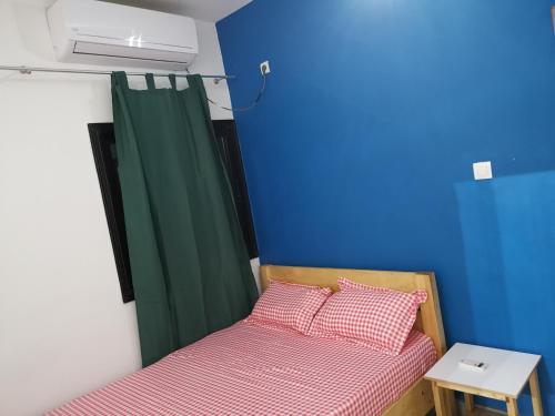 a bedroom with two beds and a green curtain at Sweet Home in Dakar
