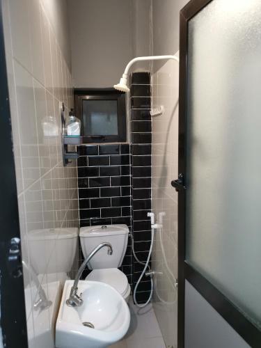a small bathroom with a toilet and a sink at Sweet Home in Dakar