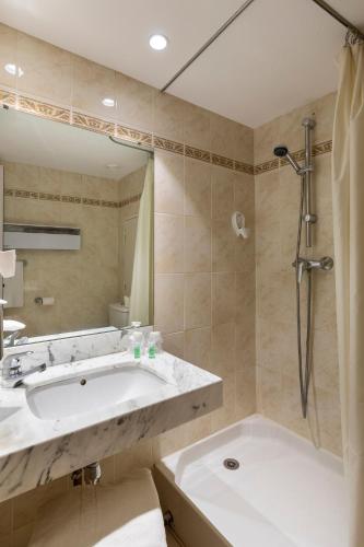 une salle de bain avec une baignoire, un lavabo et une douche dans l'établissement The Originals Residence, Kosy Nancy Coeur de Ville, à Nancy