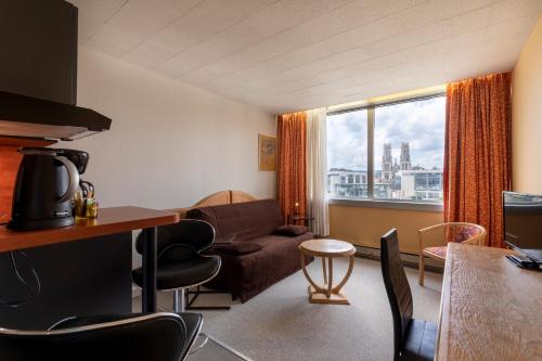 a living room with a couch and a table at The Originals Residence, Kosy Nancy Coeur de Ville in Nancy