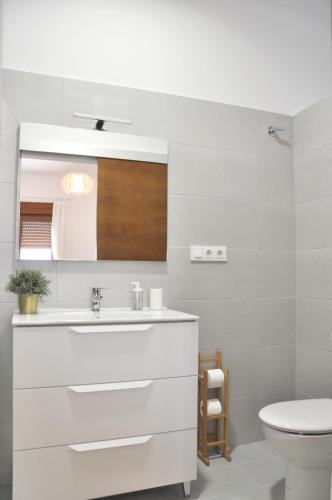 a white bathroom with a sink and a toilet at Ca Tía Teresa in Denia