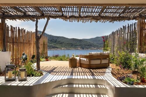 un patio con un banco y vistas al agua en Six Senses Ibiza, en Portinatx