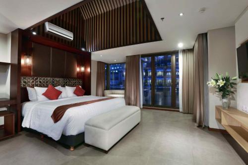 ASTON Sentul Lake Resort & Conference Center في بوغور: غرفة نوم بسرير كبير ونافذة كبيرة